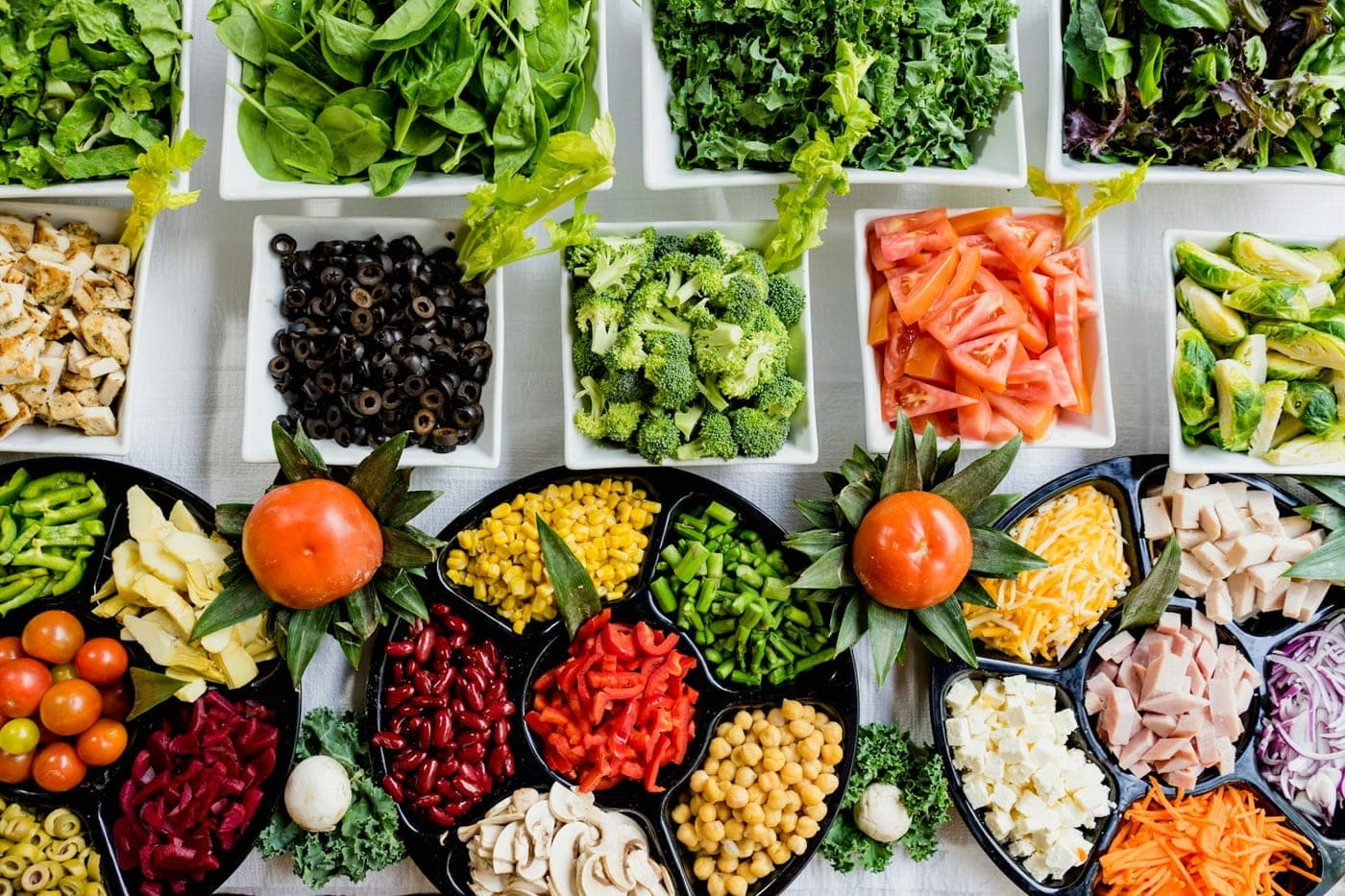 Trays of fresh vegetables and prepared ingredients.